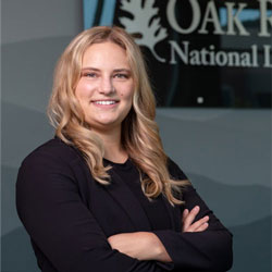 Woman with blonde hair crossing arms and smiling