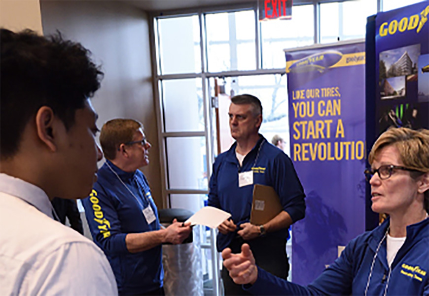 Student and a Goodyear recruiter talking at a career fair