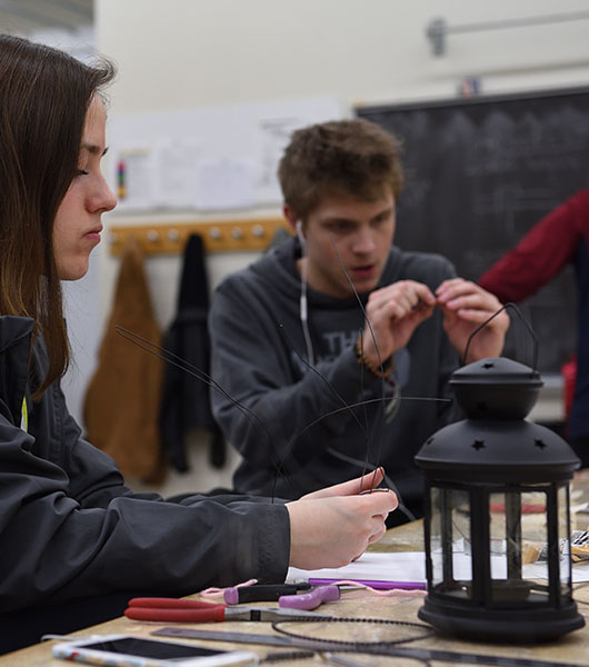 Jewelry and metalsmithing students work with wire and hand tools in the studio.